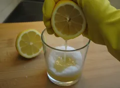 Citroen wordt uitgeperst in glas met baking soda, schoonmaken met natuurlijke middelen.