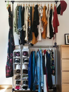 Kleding gehangen aan een bruine houten kast