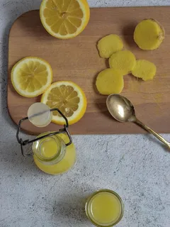 Houten snijplank met gesneden citroenen en een glas sap